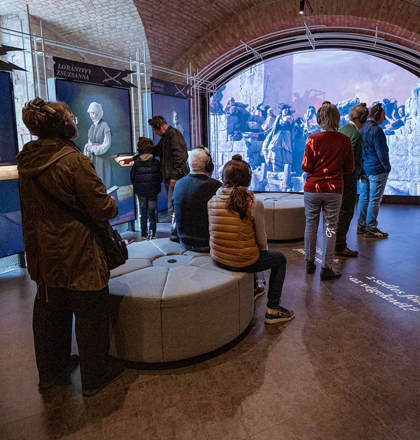 A Citadella – A Szabadság Bástyája kiállítás egyik termében látogatók történelmi témájú audiovizuális bemutatót tekintenek meg interaktív és digitális kiállítási elemek között.